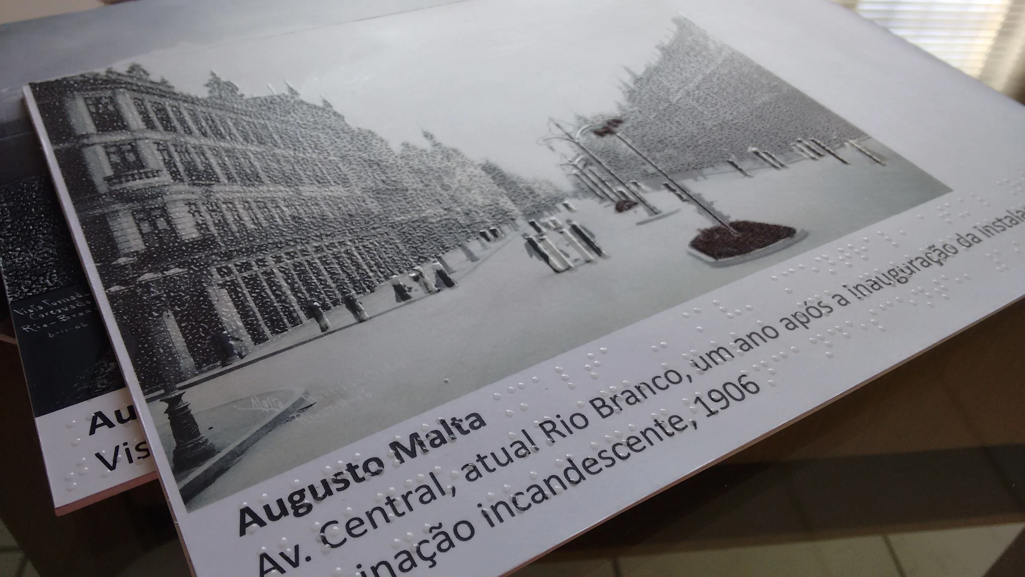 Placa ilustrada com imagem da histórica Avenida Central, atual Rio Branco com descrições em Braille impresso com serigrafia